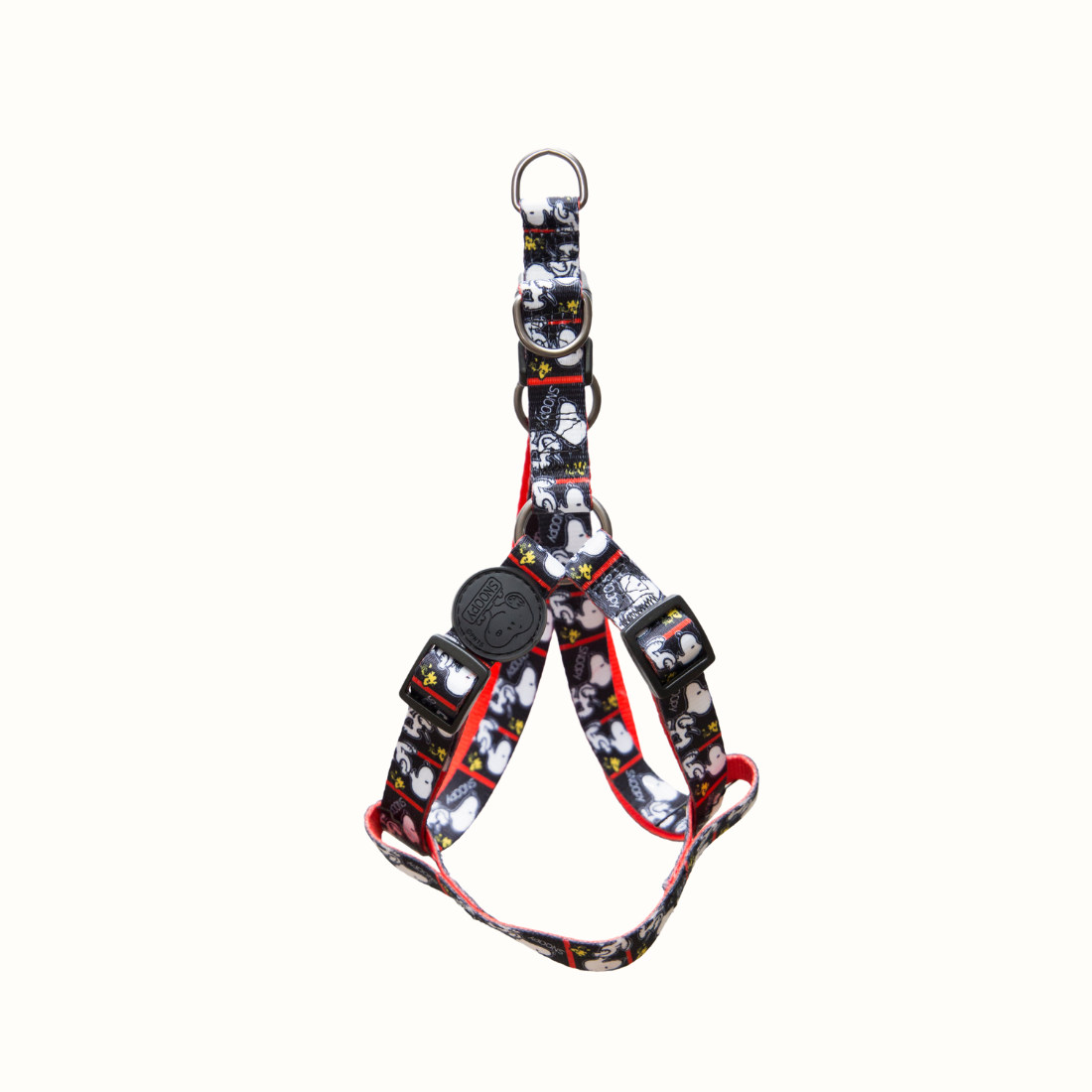 Arnês Zooz, de cores preto e branco com detalhes vermelhos e figuras do snoopy. Vista de frente, sobre fundo branco.