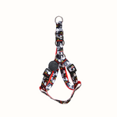 Arnês Zooz, de cores preto e branco com detalhes vermelhos e figuras do snoopy. Vista de frente, sobre fundo branco.