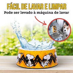 Informações do comedouro ZOOZ para animal, em plástico, com design do Snoopy, cor amarelo e preto, com imagens do personagem. Vista Frontal, sobre fundo branco.