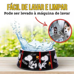 Informações sobre o comedouro ZOOZ para animal, em plástico, com design do Snoopy, preto e branco com detalhes vermelho. Vista frontal sobre fundo branco.