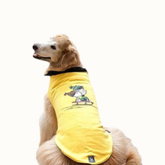 Colete Zooz para cão na cor amarela, com detalhes em preto, com estampa do personagem a deslizar na neve com um gorro e cachecol, acompanhado do Woodstock. Vista das costas de um cão, sobre fundo branco.
