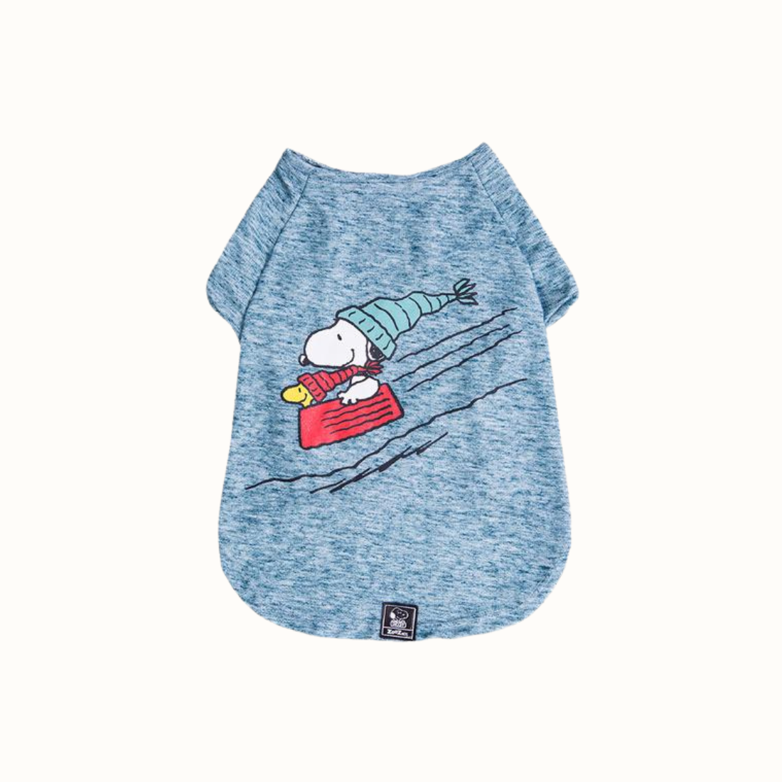 Camisola para cão com design do Snoopy, em azul mesclado. Estampa do Snoopy a deslizar na neve com um gorro e cachecol, acompanhado do Woodstock. Vista frontal sobre fundo branco.
