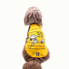 Camisola ZOOZ para cão com design do Snoopy, da cor amarelo, com detalhes pretos. Estampa divertida do personagem a rir. Vista das costas de um cão, sobre fundo branco.