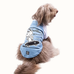 Camisola ZOOZ para cão com design do Snoopy, de cor azul, com detalhes em branco. Estampa divertida do personagem a andar de skate. Vista das costas de um cão, sobre fundo branco.