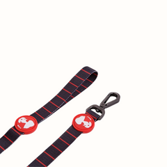 Trela Snoopy Zooz em padrão preto com detalhes em vermelho e figura do personagem. Vista em pormenor, sobre fundo branco.