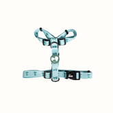 Arnês Zooz, em padrão azul claro e verde claro e figuras do snoopy. Vista de frente, sobre fundo branco.