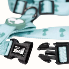 Arnês Zooz, em padrão azul claro e verde claro e figuras do snoopy. Vista em detalhe, sobre fundo branco.