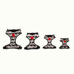 Arnês peitoral Zooz, de padrão preto e branco em zig-zag com figuras do snoopy, de vários tamanho. Vista de frente, sobre fundo branco.