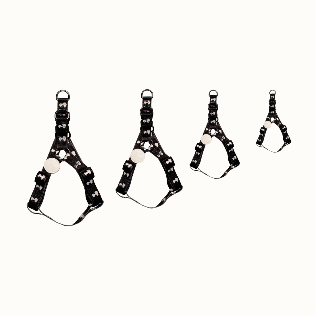 Arnês Zooz, em padrão preto e branco, com figuras do snoopy, vários tamanhos. Vista de frente, sobre fundo branco.