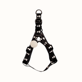 Arnês Zooz, em padrão preto e branco, com figuras do snoopy. Vista de frente, sobre fundo branco.