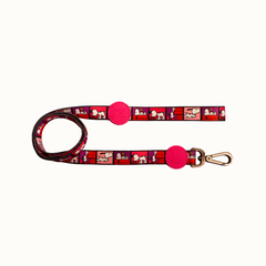 Trela Zooz ajustável, de padrão cor de rosa, vermelho e roxo, com detalhes vermelhos e com figuras do snoopy.
Vista de frente, sobre fundo branco.