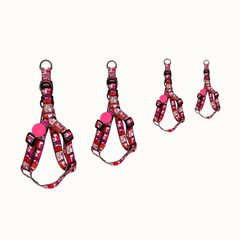 Arnês Zooz, em padrão cor de rosa, vermelho e roxo, com figuras do snoopy, vários tamanhos. Vista de frente, sobre fundo branco.