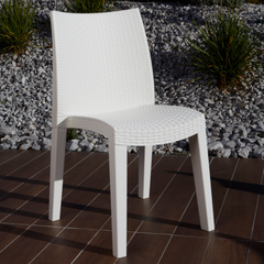 Cadeira IPAE PROGARDEN em plástico, de cor branca, com encosto e assento com acabamento trançado. Exibido em ambiente exterior.