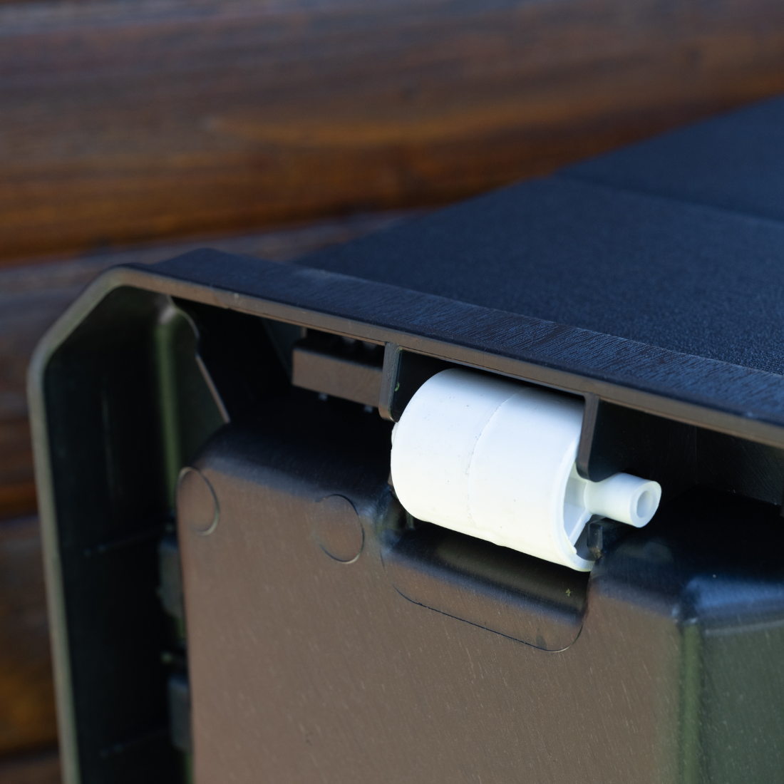 Baú de arrumação IPAE PROGARDEN, de plástico com efeito madeira, de cor cinzenta, exibido em ambiente externo e em pormenor.