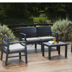 Conjunto de dois cadeirões e um cadeirão duplo baixos e uma mesa baixa quadrada IPAE PROGARDEN, da cor cinzenta, com almofada no assento e padrão entrançado. Exibido em ambiente exterior.