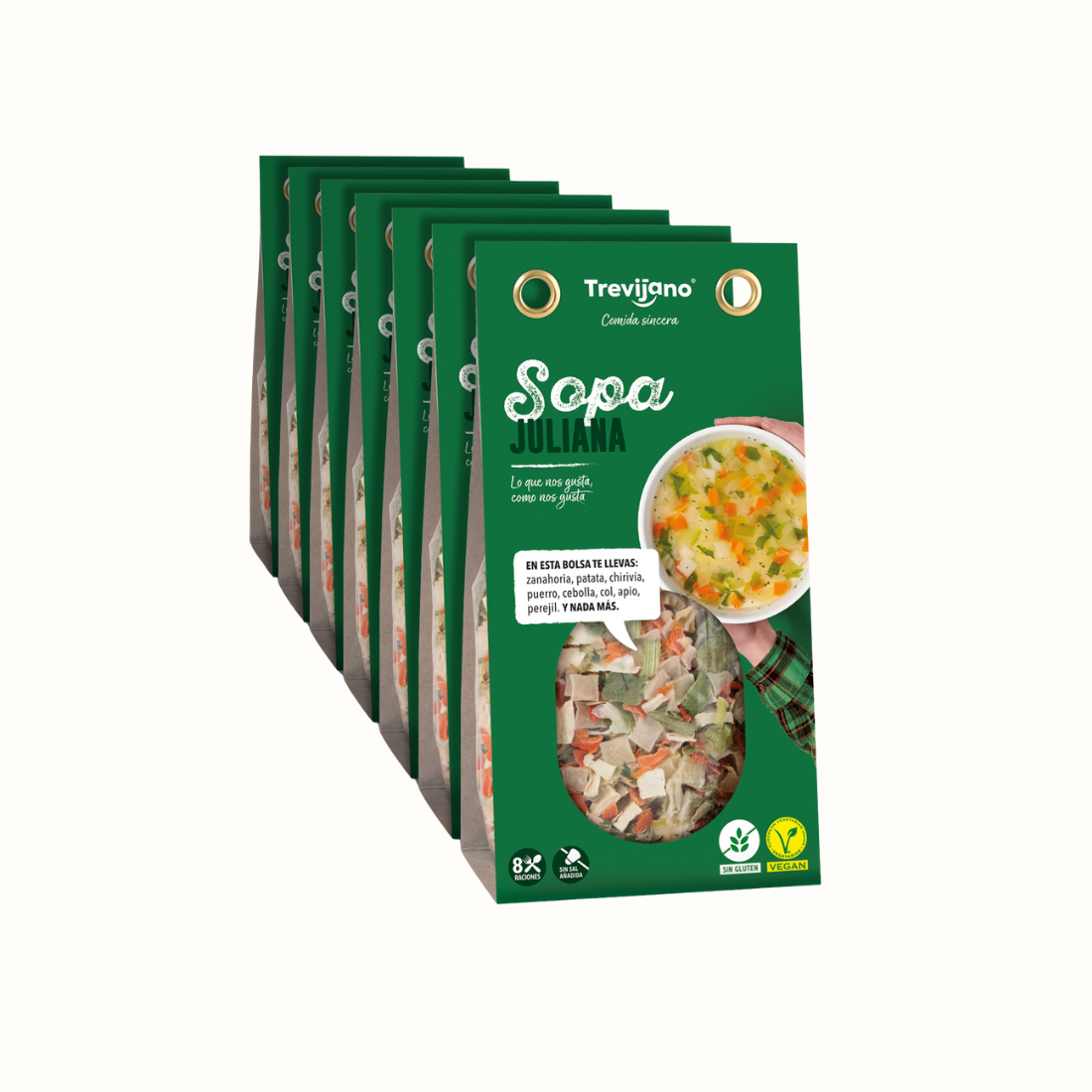 Sopa juliana em embalagem de cartão e plástico transparente, com pedaços de legumes variados como cenoura, couve e cebola. A embalagem tem um rótulo verde com o nome do produto e informações nutricionais. Fundo branco.
