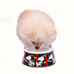 Comedouro ZOOZ para animal, em plástico, com design do Snoopy, preto e branco com detalhes vermelho. Vista frontal, exibido num cão, em ambiente exterior.