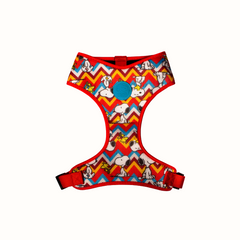 Arnês peitoral Zooz, de cor vermelha, azul, amarela e branca em zig-zag com detalhes do personagem. Vista de frente, sobre fundo branco.