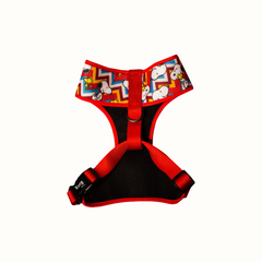 Arnês peitoral Zooz, de cor vermelha, azul, amarela e branca em zig-zag, com detalhes do personagem e forro preto. Vista de frente, sobre fundo branco.