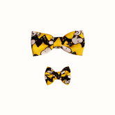 Coleira do Snoopy Zooz para animal, de padrão amarelo, preto e branco, com imagens do personagem e um laço do mesmo padrão. Vista frontal, de vários tamanhos, sobre fundo branco.