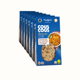 Cous Cous Mediterraneo Trevijano em embalagem de cartão e plástico transparente, com uma mistura de vegetais desidratados, ervas aromáticas e especiarias. A embalagem tem um rótulo com o nome do produto e informações nutricionais. Fundo branco.