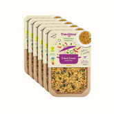 Cous Cous à Tailandesa Trevijano em embalagem de cartão e plástico transparente, com uma mistura de vegetais desidratados e proteína vegetal. A embalagem tem um rótulo com o nome do produto e informações nutricionais. Fundo branco.