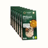 Paella 6 Verduras Trevijano em embalagem de cartão e plástico transparente, com uma mistura de vegetais desidratados, incluindo açafrão e pimentão. A embalagem tem um rótulo com o nome do produto e informações nutricionais. Fundo branco.