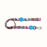 Trela Snoopy Zooz, de cor azul, amarela e branca em zig-zag com detalhes do personagem. Vista de frente, sobre fundo branco.