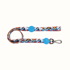 Trela Snoopy Zooz, de cor azul, amarela e branca em zig-zag com detalhes do personagem. Vista de frente, sobre fundo branco.