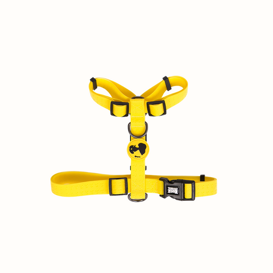 Arnês Snoopy Zooz, de cor amarelo com detalhes em preto. Vista de frente, sobre fundo branco. 