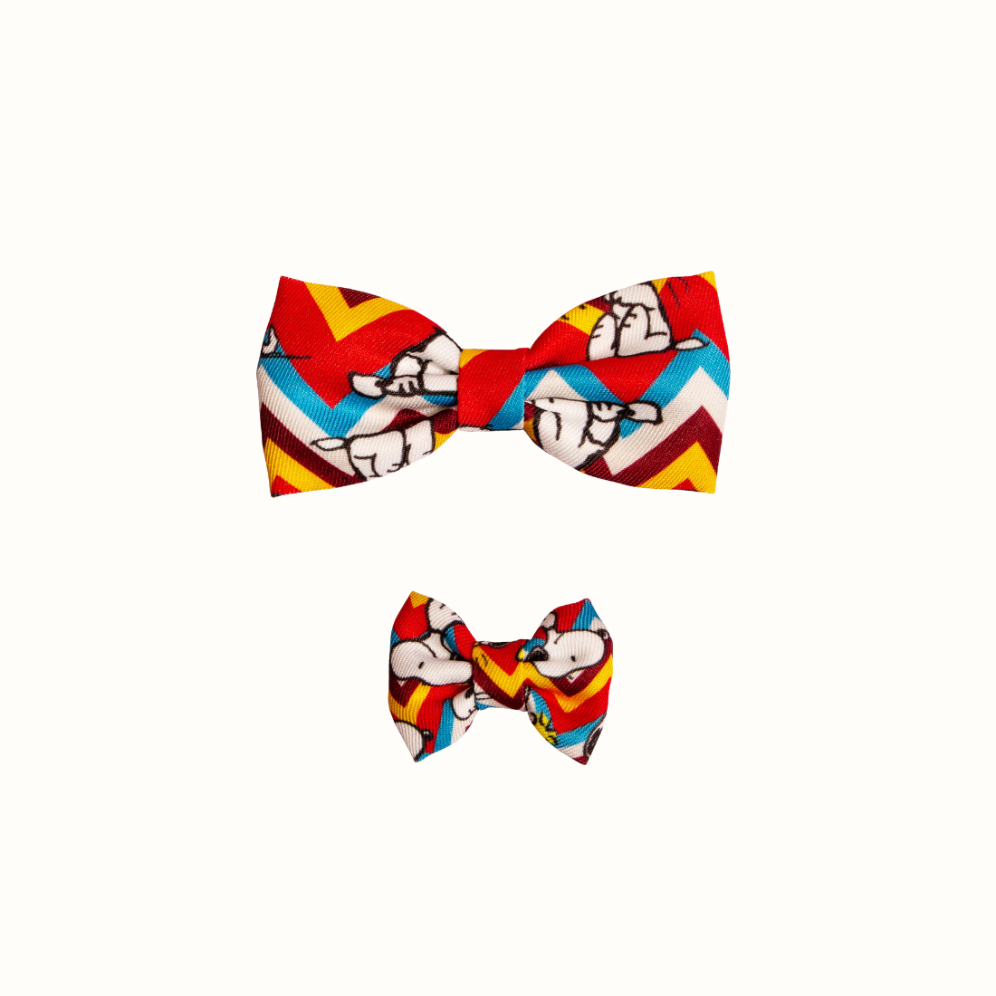 Coleira do Snoopy Zooz para animal, de padrão em zig-zag colorido, com imagens do personagem e um laço do mesmo padrão. Vista frontal, de varios tamanhos, sobre fundo branco. 