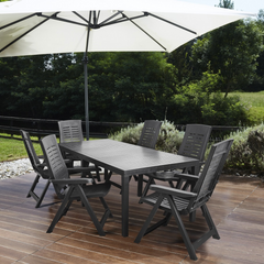Mesa IPAE PROGARDEN em plástico, de cor preta, com ranhuras e 6 pés de suporte. Exibido em ambiente exterior. 