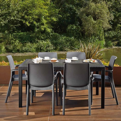 Conjunto de 4 Cadeiras IPAE PROGARDEN em plástico, de cor cinzenta, com braços e encosto de apoio. Exibido em ambiente exterior. 
