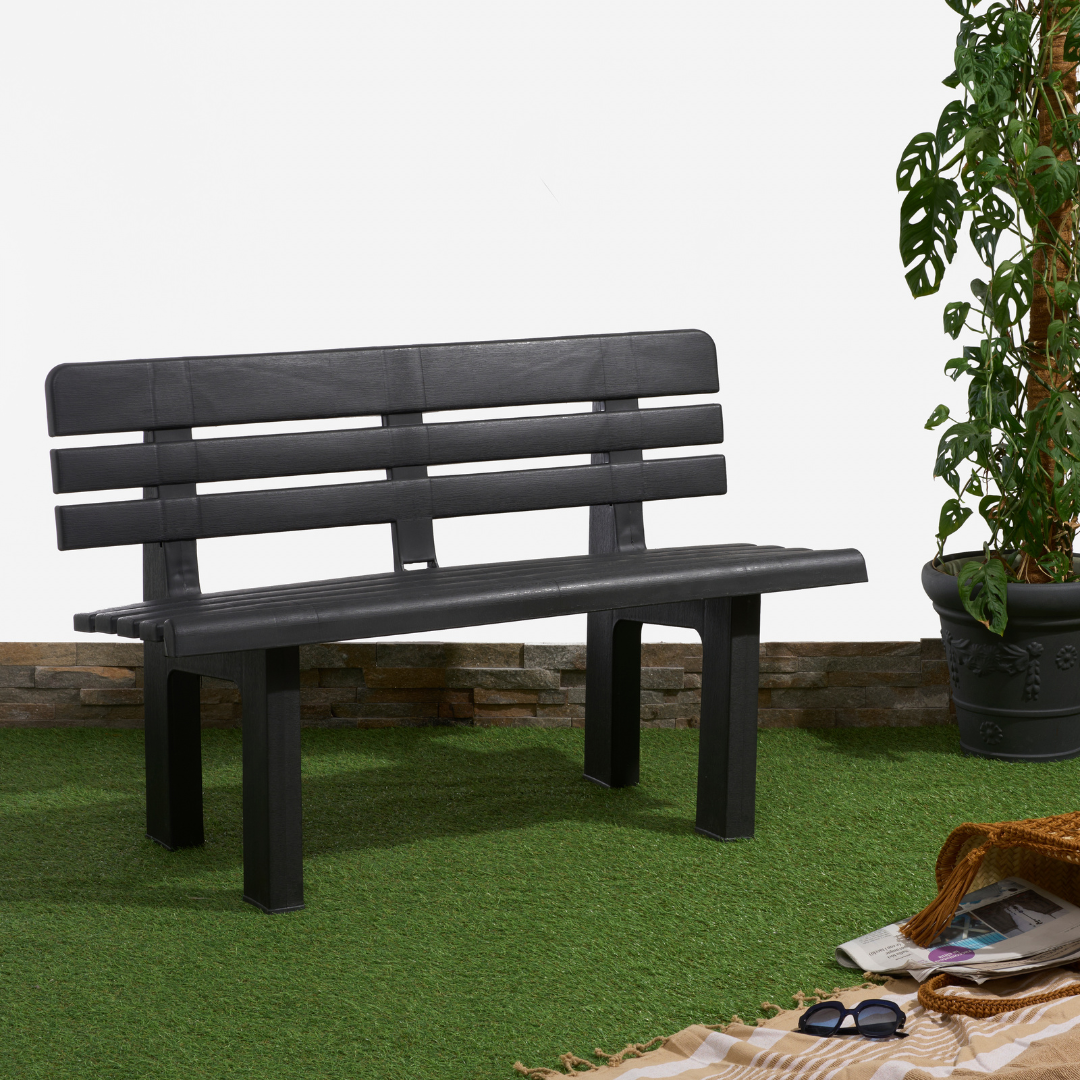 Banco IPAE PROGARDEN em plástico preto, com encosto composto por ripas horizontais, exibido em ambiente externo. 