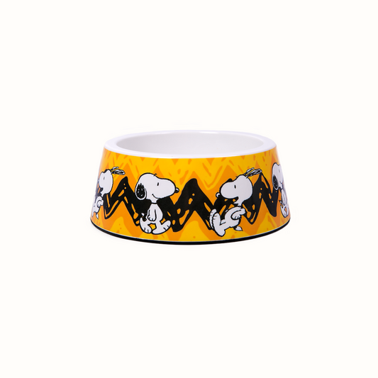 Comedouro ZOOZ para animal, em plástico, com design do Snoopy, cor amarelo e preto, com imagens do personagem. 
Vista de cima, sobre fundo branco. 