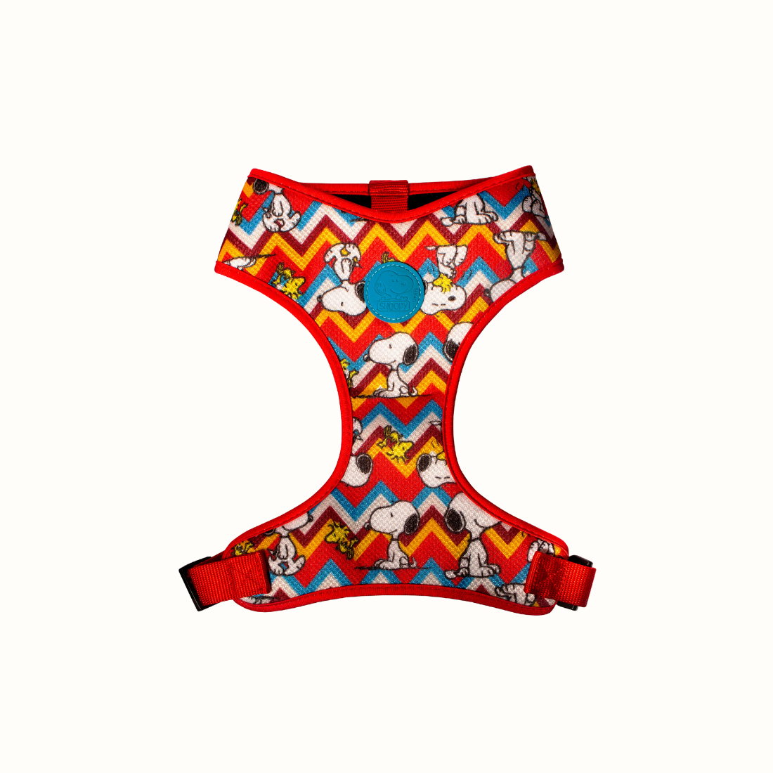 Arnês peitoral Zooz, de cor vermelha, azul, amarela e branca em zig-zag com detalhes do personagem. Vista de frente, sobre fundo branco. 