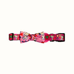 Coleira do Snoopy Zooz para animal, de padrão cor de rosa, floral, com imagens do personagem e um laço do mesmo padrão. Vista frontal, sobre fundo branco. 