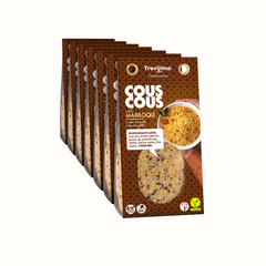 Cous Cous Marroquino Trevijano em embalagem de cartão e plástico transparente, com uma mistura de vegetais desidratados, ervas aromáticas e especiarias marroquinas. A embalagem tem um rótulo com o nome do produto e informações nutricionais. Fundo branco.
