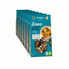 Sopa juliana do mar em embalagem de plástico transparente, com pedaços de peixe, marisco e legumes variados como cenoura, couve e cebola. A embalagem tem um rótulo azul com o nome do produto e informações nutricionais. Fundo branco.